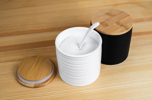 A kitchen set that includes sugar  pepper and salt with a spoon