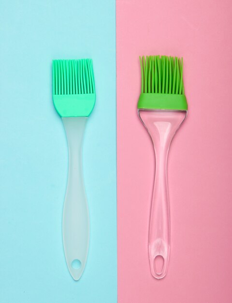 Kitchen spatula and brush on pink blue pastel background. Top view