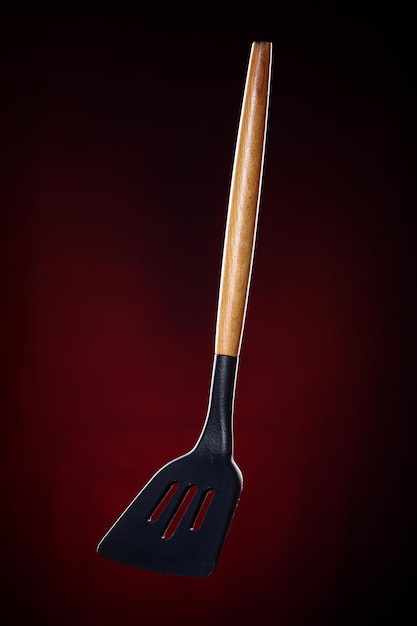 Kitchen spatula for turning meat This is a promotional photo of kitchen utensils on a dark background