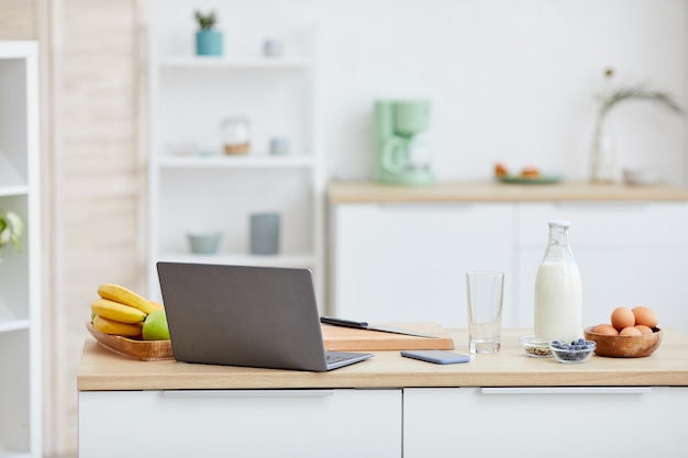 kitchen table with fruits and laptop computer on it in domestic kitchen