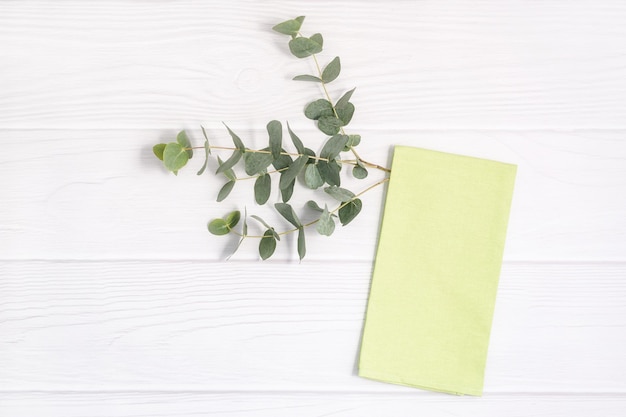 Kitchen towel and Eucalyptus twig on white wood tabletop Can use as mock up for design