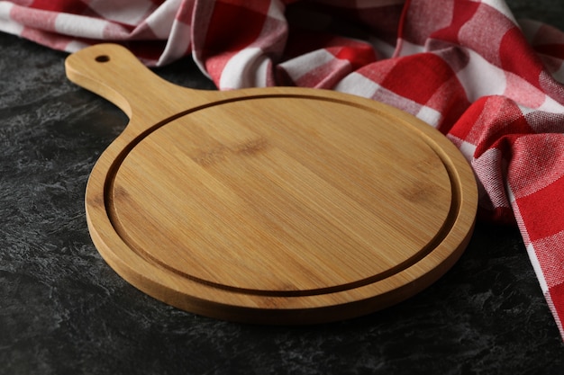 Kitchen towel and wooden board on black