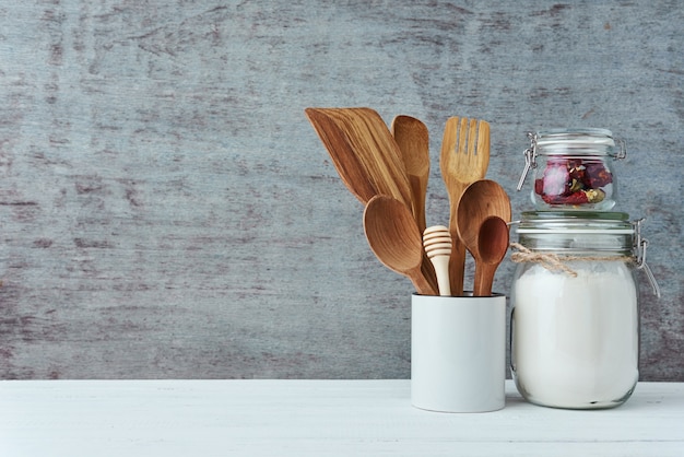 Kitchen utensils in ceramic cup on a gray background, copy space