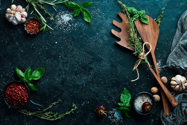 Kitchen utensils spices and herbs on a stone background Cooking concept Top view Free space for your text