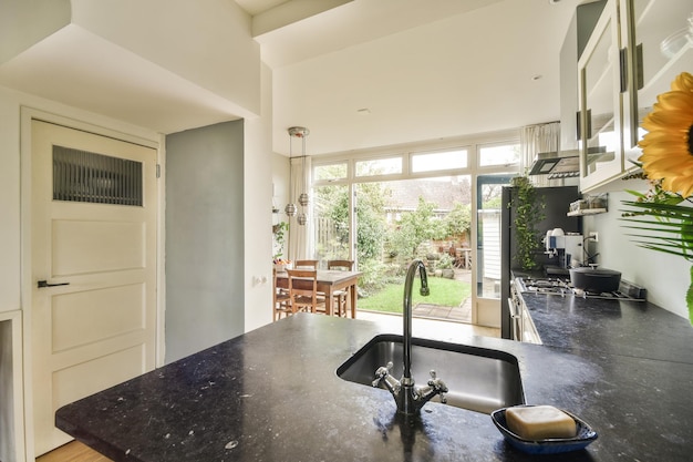 A kitchen with a black counter top and a sink