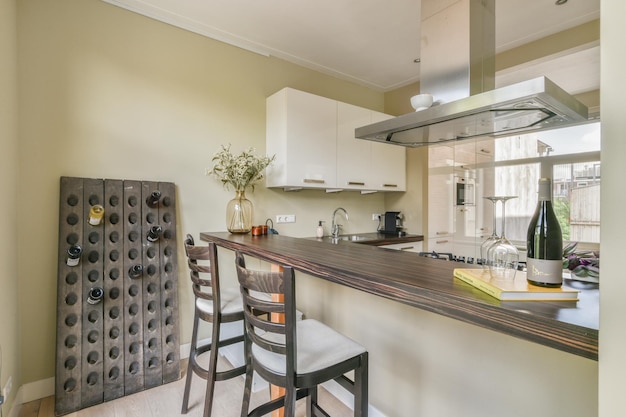 A kitchen with a long bar with three stools