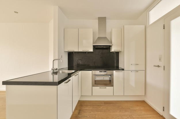 A kitchen with white cabinets and a black counter top