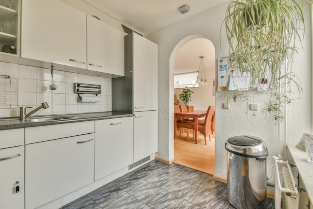 A kitchen with white cabinets and a sink