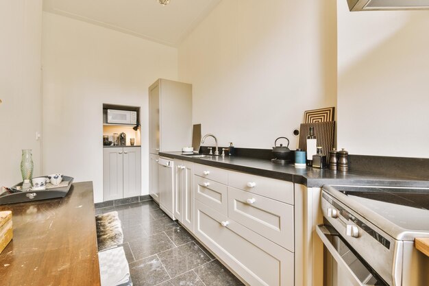 A kitchen with white cabinets and a stove and sink