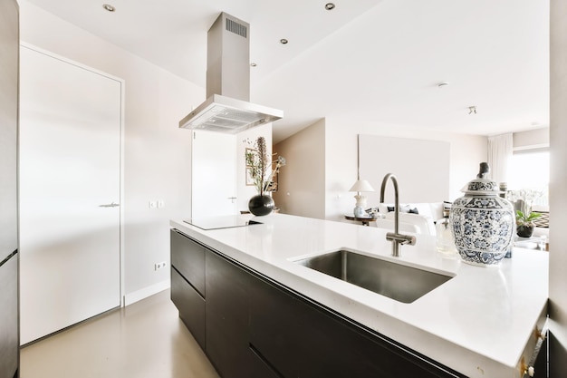 A kitchen with white countertops and a black sink