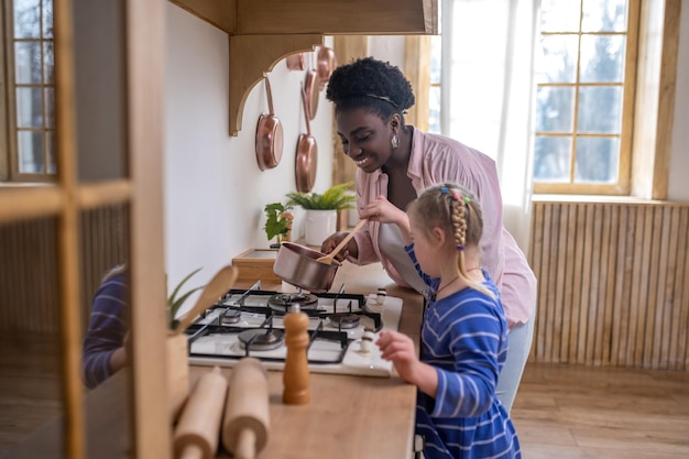 In the kitchen. A woman and a girl looking busy while doing some housework