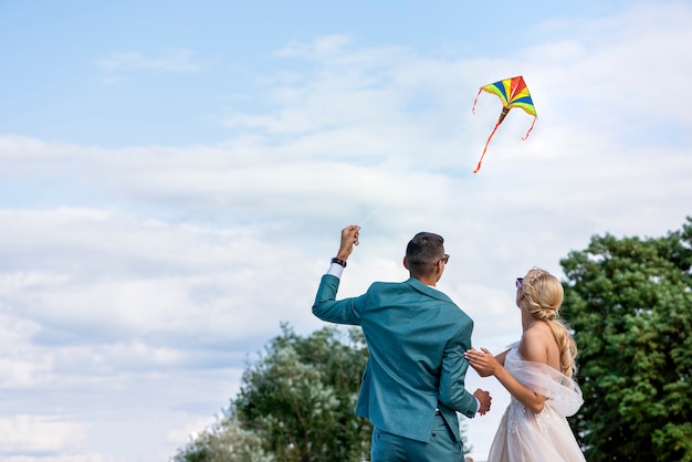 A kite at a wedding a wedding couple launches a kite into the sky bride and groom fly a kite togethe...