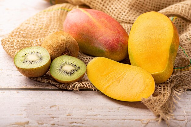 Kiwi fruit and mango kiwi fruit and mango placed on rustic wood with rustic fabric selective focus