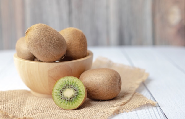 Kiwi fruits in a bowl place on the wooden table