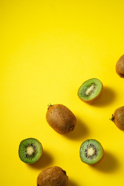 Kiwi fruits half sliced on vibrant plain yellow