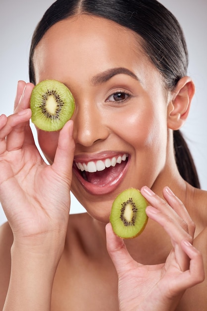 Kiwi makes for a nourishing booster to your skincare routine Studio portrait of a beautiful young woman posing with kiwi against a grey background