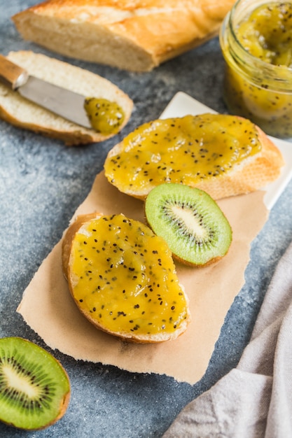 Kiwi marmalade on fresh bread on the table