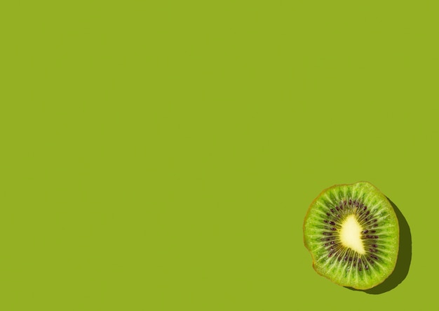 Kiwi slice on green with copy space top view