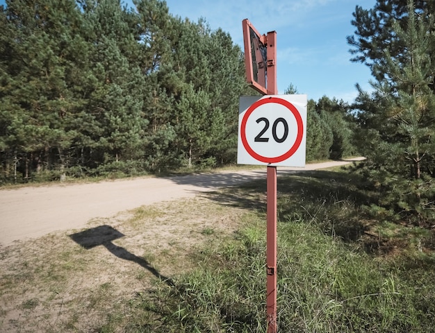 km per hour speed limit sign near ground road in nature