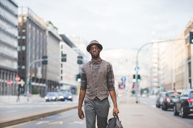 Knee figure of young handsome afro black man walking in the street of the city