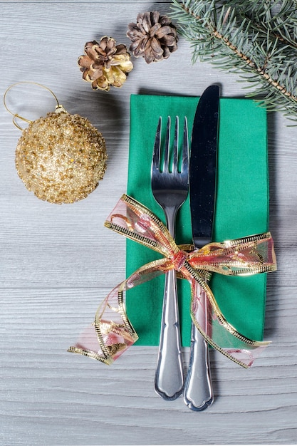 Knife and fork on green napkin in New Year's scenery