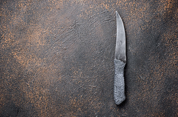 Photo knife on rusty table. culinary background 