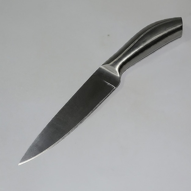 a knife with a black handle is laying on a table