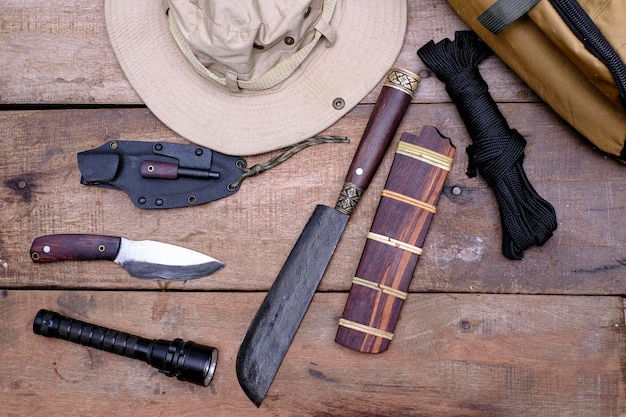 A knife with equipment for survival in the forest on an old wooden floor