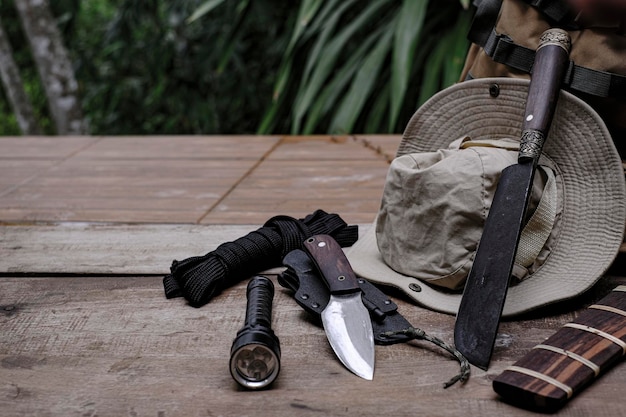 A knife with equipment for survival in the forest on an old wooden floor