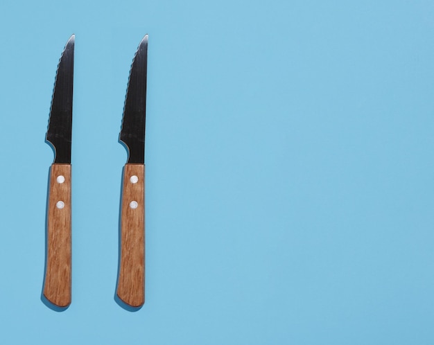 Knife with a wooden handle on a blue background top view