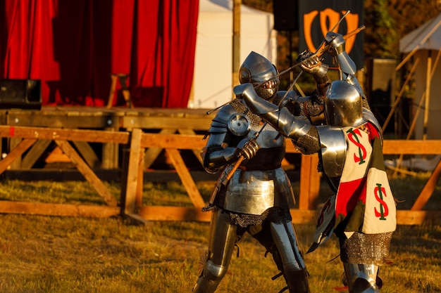 Knights in medieval armor fight at the tournament in the summer. High quality photo