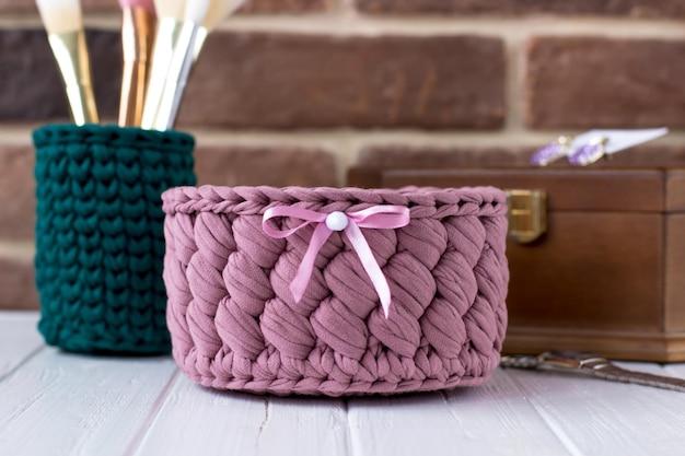 Knitted basket of blue and green colors decorated with a silver heart