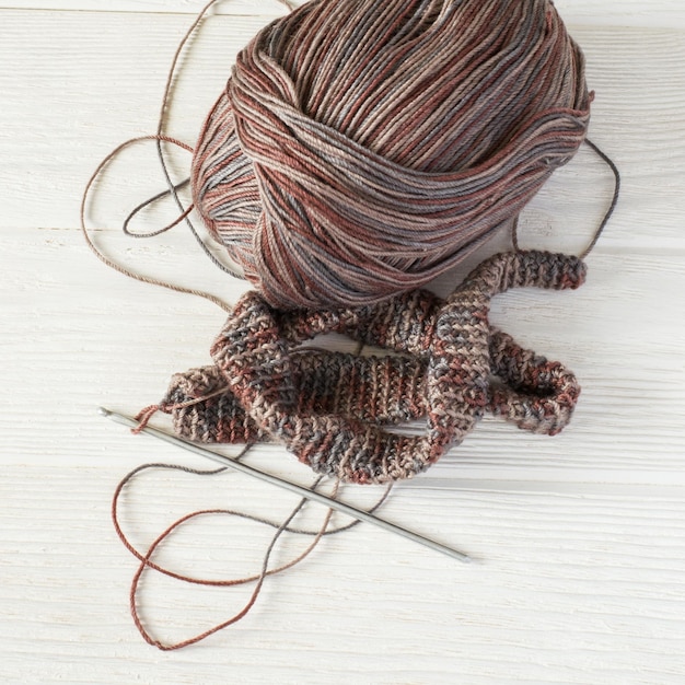 Knitted fabric in Gray winter tones, Ball of threads and crochet hook.