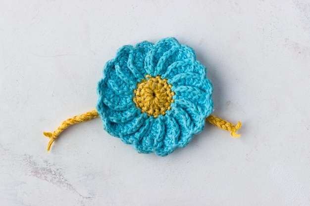 Knitted flower in the colors of the Ukrainian flag Blue yellow flower on a white background