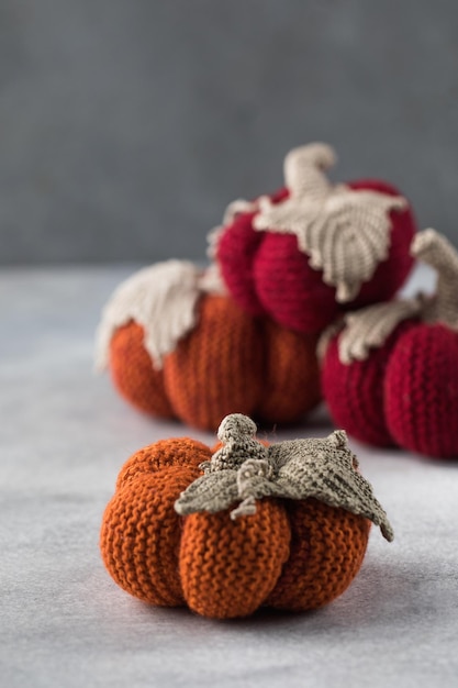 Knitted handmade pumpkins on a grey background Autumn and coziness DIY decor