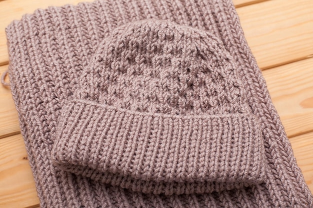 Knitted hat and scarf on grey background