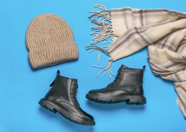 Knitted hat scarf and a pair of shoes on a blue background