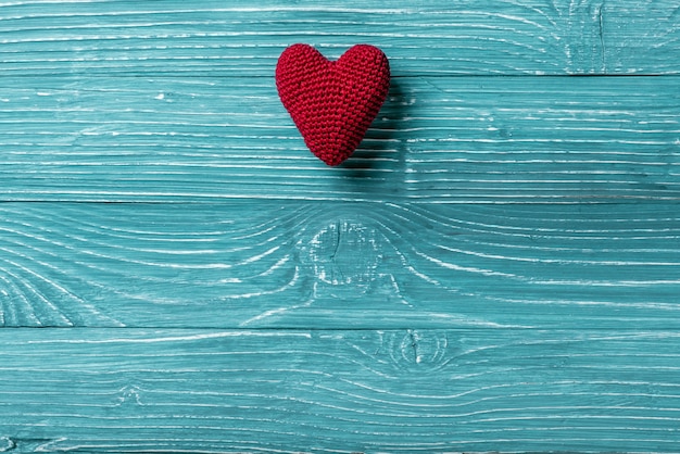 Knitted heart on a blue wooden background