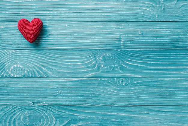 Knitted heart on a blue wooden background