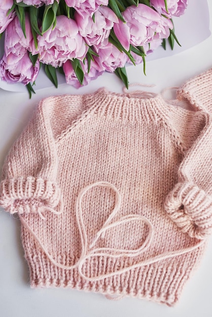 Knitted kids clothes and accessories for knitting Needlework and knitting Hobbies and creativity Knit for children Handmade Pink sweater and tulips