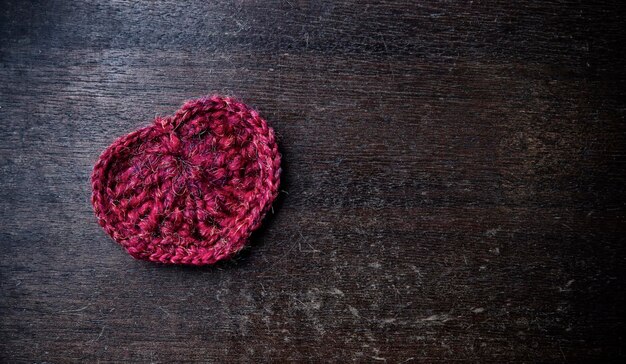 Knitted red heart. Background for Valentine's day. Wooden pattern. Retro style.