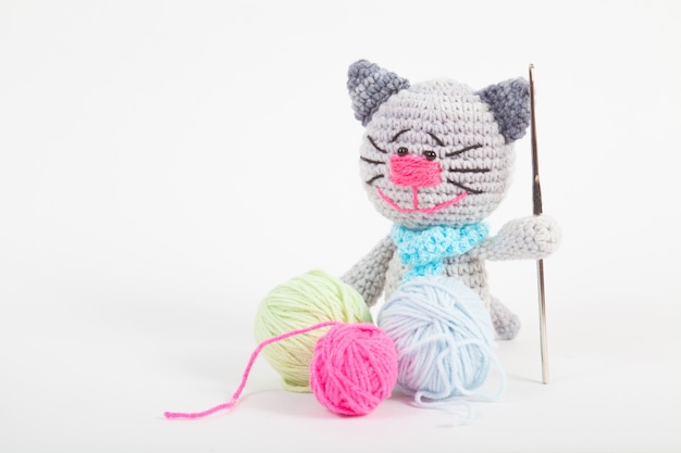 Knitted small cat on an white background. Handmade, knitted toy. Amigurumi