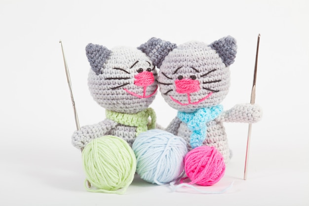 Knitted small cat on an white . Handmade, knitted toy. Amigurumi