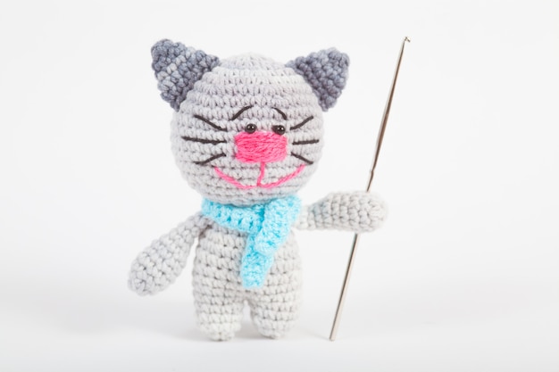 Knitted small cat on an white . Handmade, knitted toy. Amigurumi