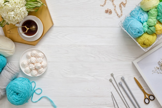 Knitting tools with tea on a wooden floor