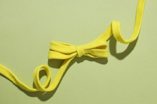 A knot of yellow braided lace on a light background