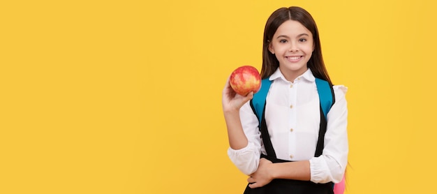 Knowledge day is here Happy girl smile holding apple Portrait of schoolgirl student studio banner header School child face copyspace