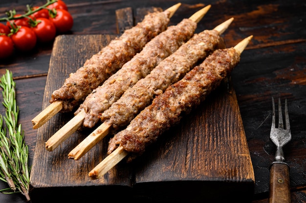 Kofta or lula beef and lamb meat kebabs skewers set, on serving board, on old dark  wooden table background