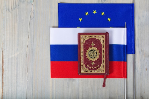 Koran and helicopter on flags of EU and Russia