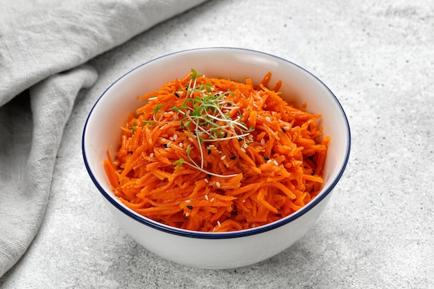 Korean Asian carrot salad with sauce and spices in a bowl Vegetable salad with carrot sesame seeds